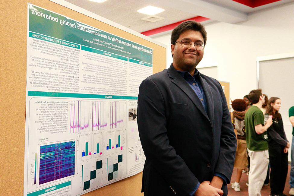 Avinash Kanakam standing in front of his research poster